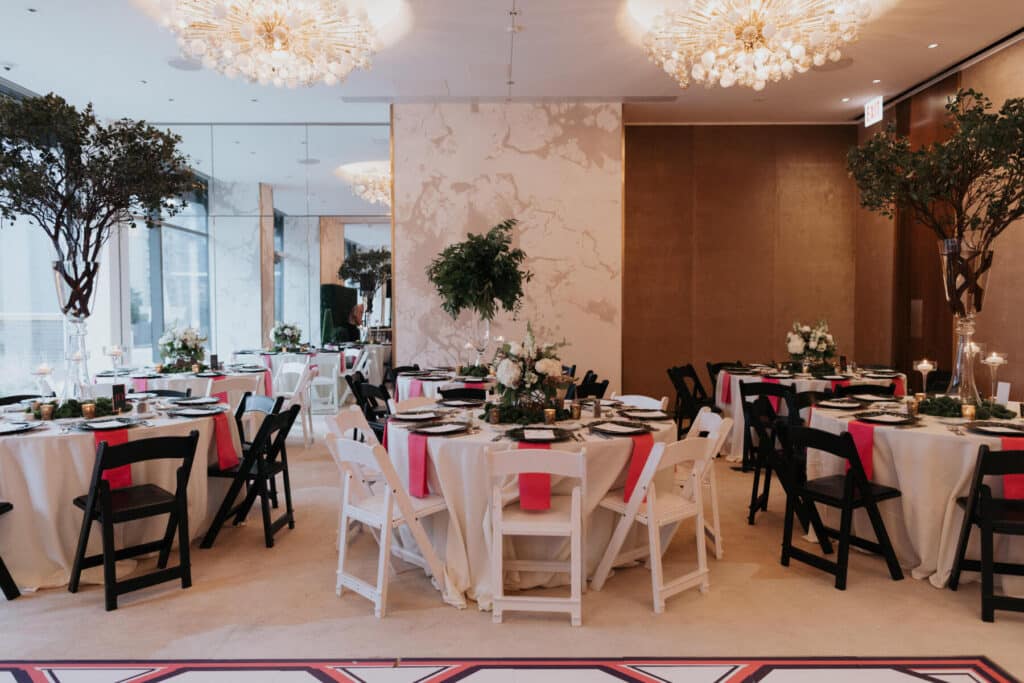 Carats & Cake Feature, Nomi Art Gallery Chicago wedding reception featuring black and white resin folding chairs along with sea sponge dark green chargers from Tablescapes Chicago