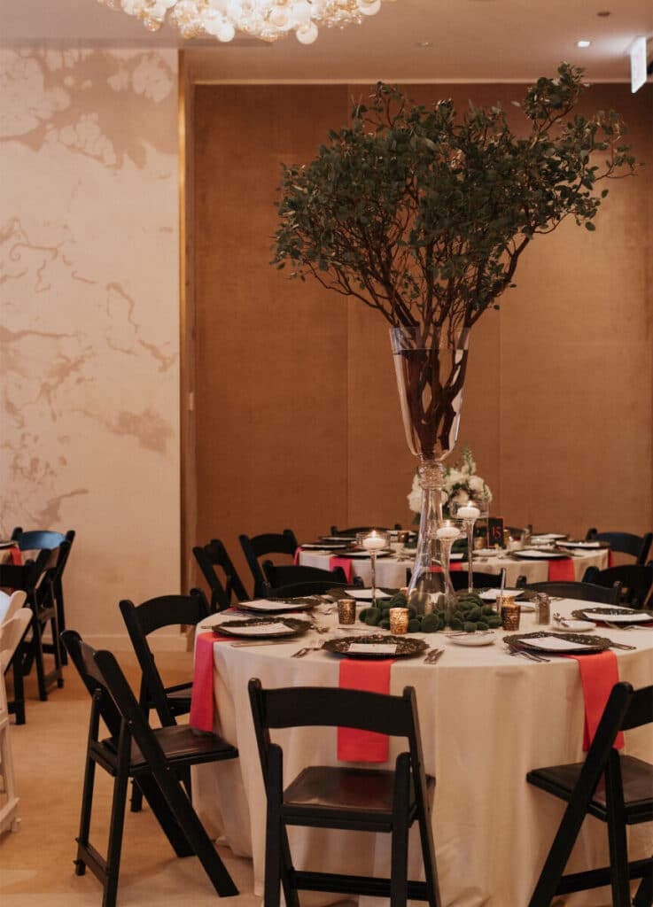 Carats & Cake Feature, Nomi Art Gallery Chicago wedding reception featuring black and white resin folding chairs along with sea sponge dark green chargers from Tablescapes Chicago