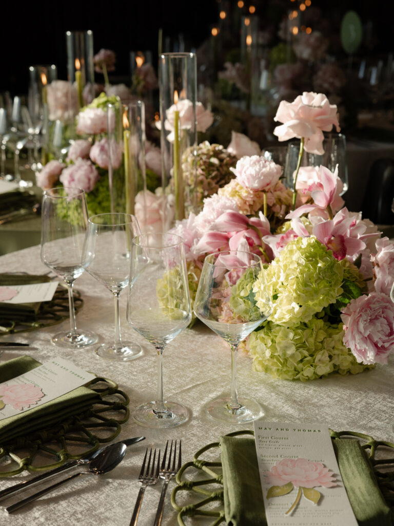 High-end wedding place setting featuring Tablescapes Pure crystal stemware, modern stainless flatware, and white coupe dinner plates