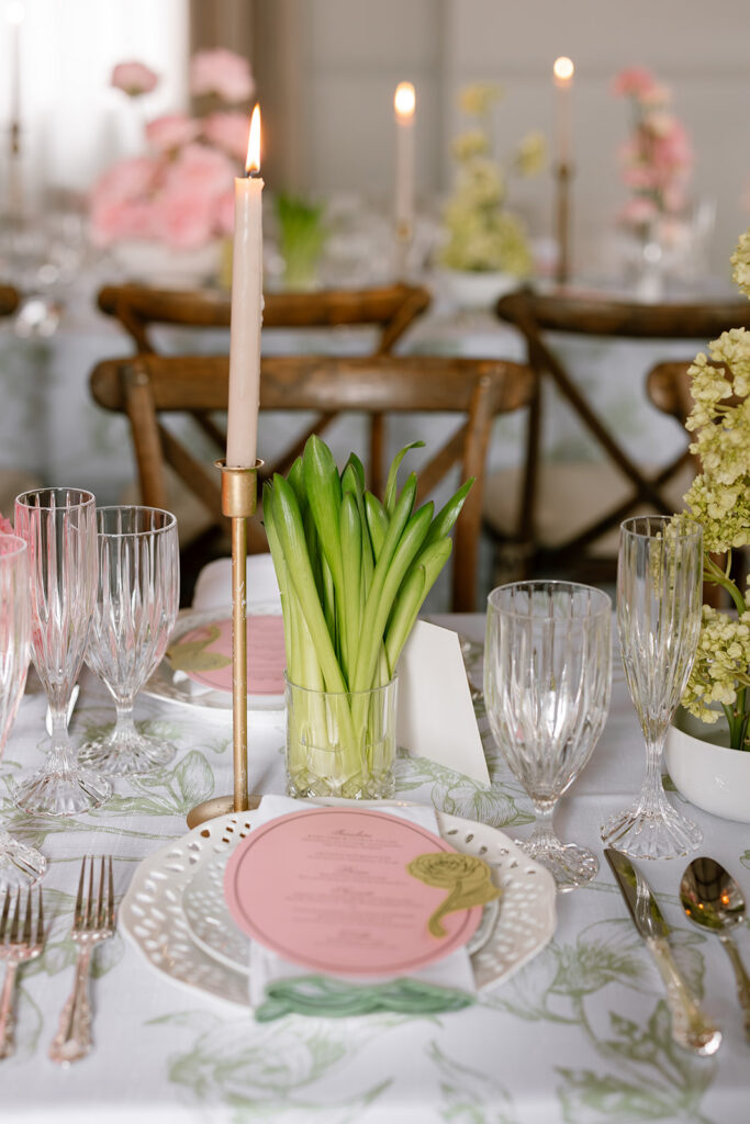 Minimalist architectural green floral arrangements in white ceramic bowls on a patterned wedding tablecloth.