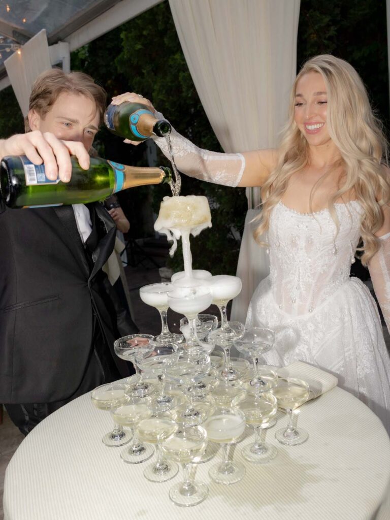 Champagne cascading and overflowing down the tiers of a champagne tower.